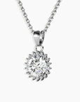Detailed close-up of the sunburst pendant, highlighting the round moissanite center and rhodium-plated silver rays.