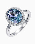 Alexandrite halo ring with colour-changing gemstone and CZ border on dark background – sterling silver