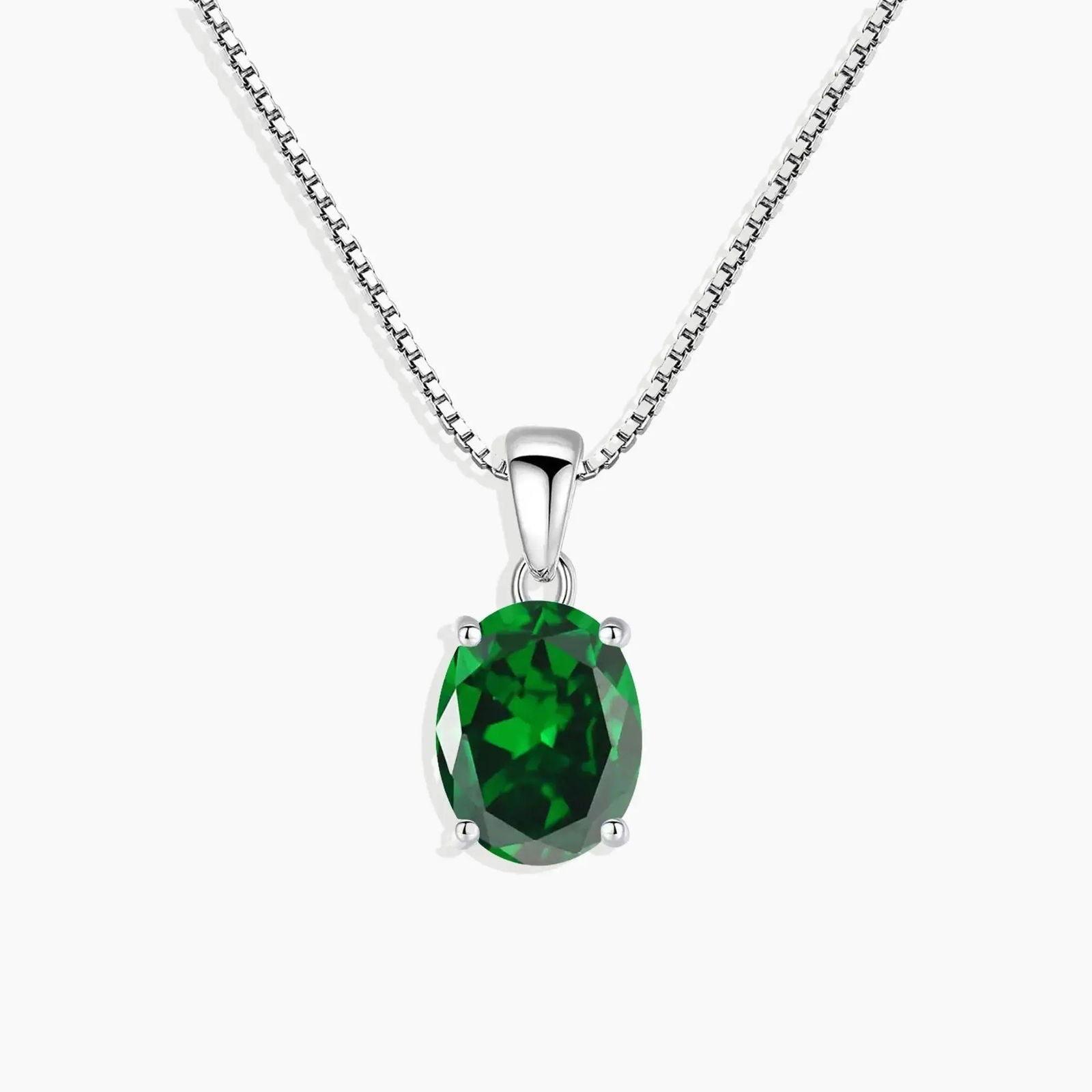 Sterling silver necklace featuring an oval-cut emerald pendant on a white background.