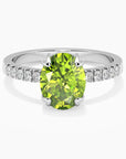 Close-up view of an elegant oval-cut peridot silver ring with a halo of sparkling CZ stones, set in rhodium-plated sterling silver