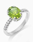 Side angle view of the oval peridot ring showcasing the detailed four-claw setting and polished silver band.