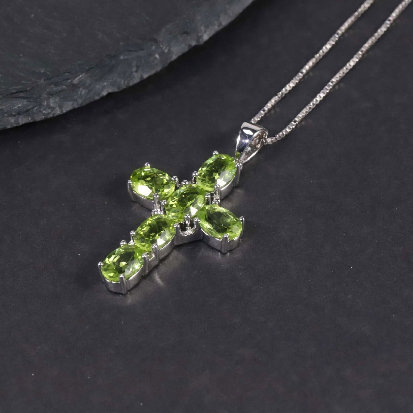 Close-up of Silver Cross Necklace with Natural Peridot Gemstones