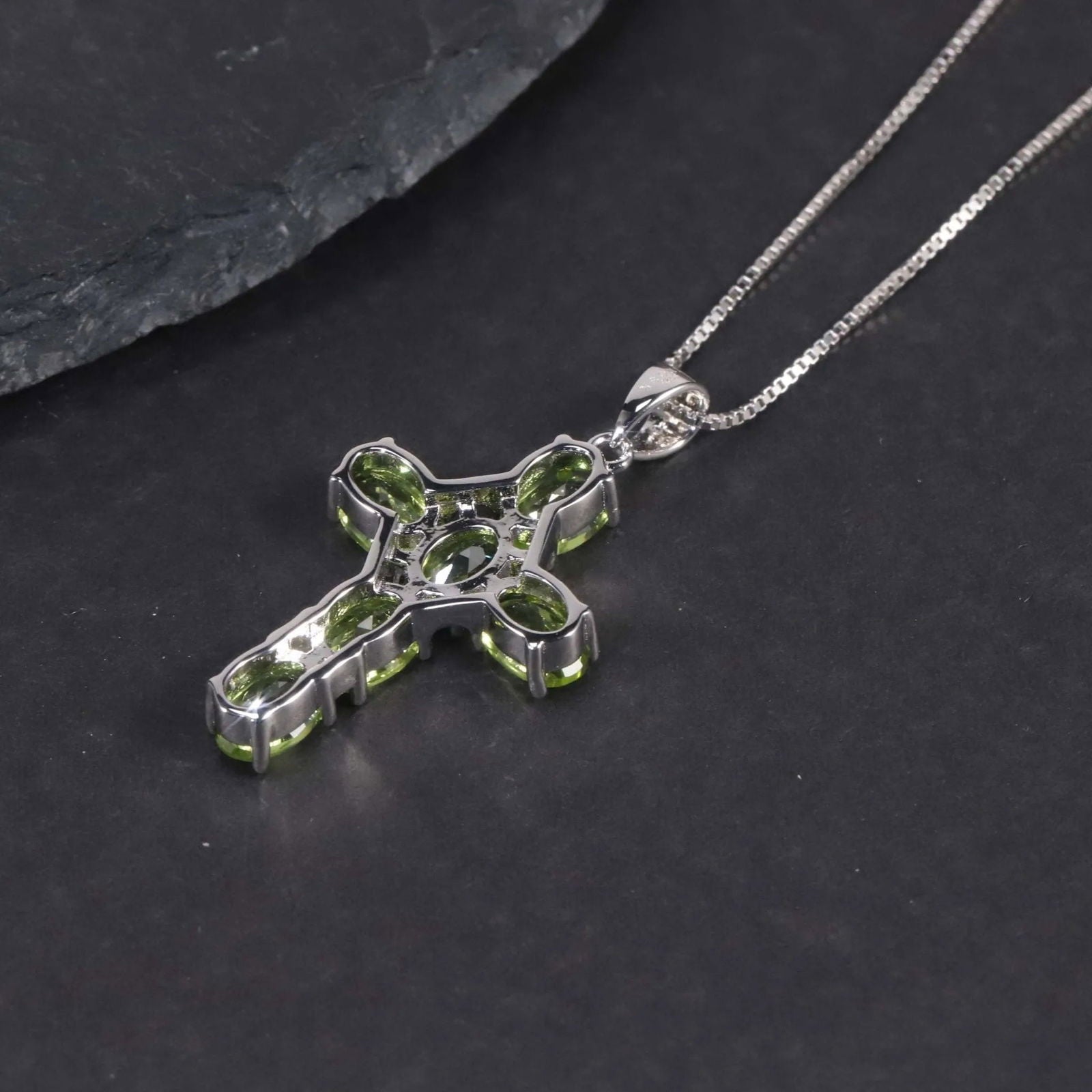 back side of silver cross necklace with peridot
