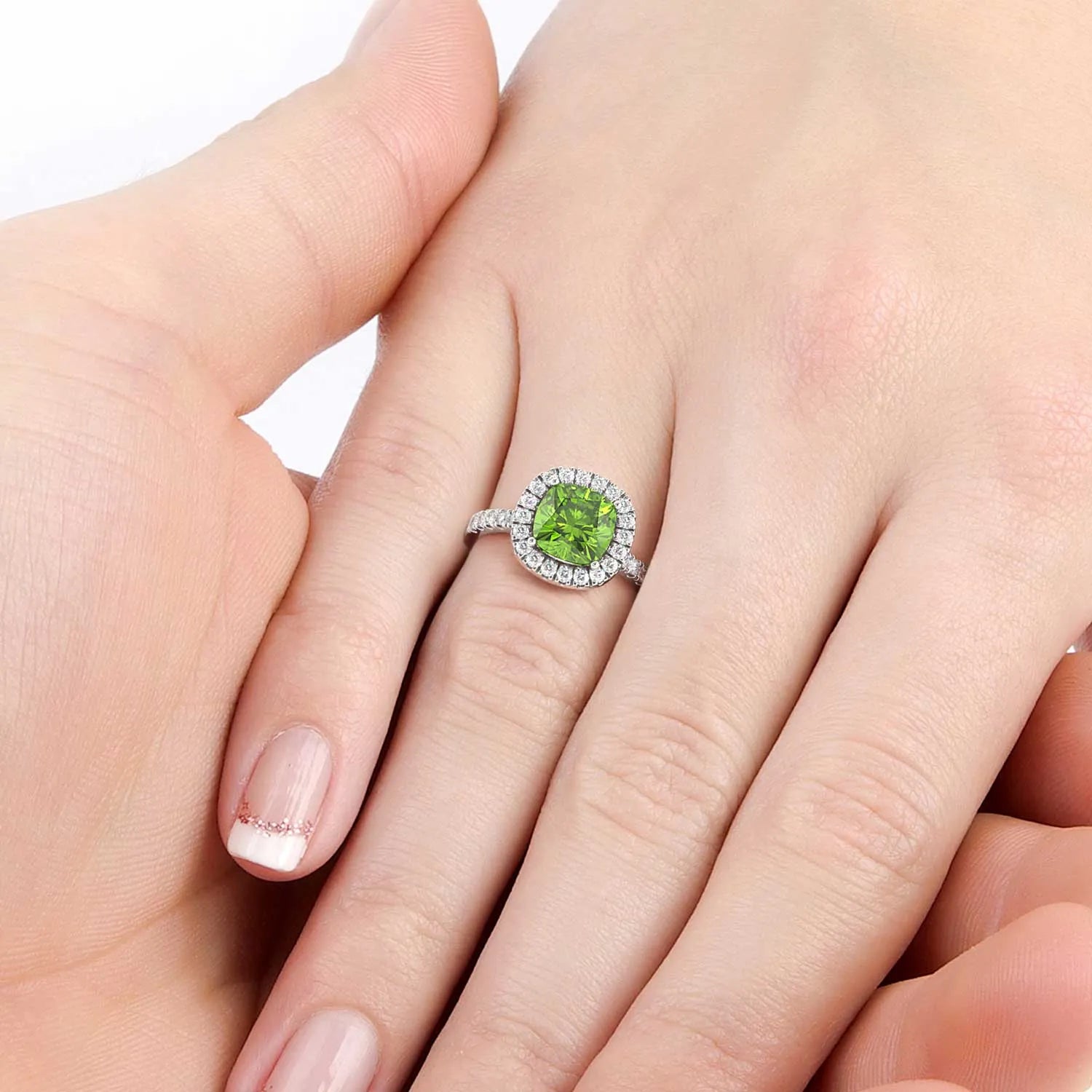 Hand wearing a Cushion Cut Peridot Halo Ring, showcasing the August birthstone in a luxurious Sterling Silver setting."