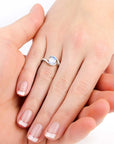 Model hand wearing the Irosk moonstone semi bezel ring, showcasing its elegant and modern curve design