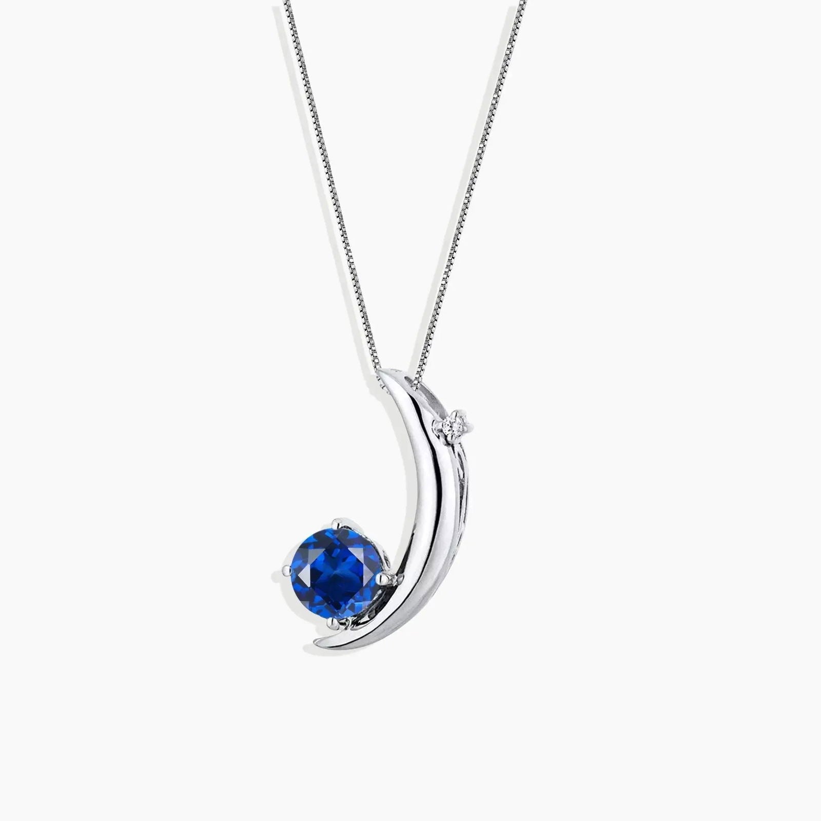Blue moon necklace in sterling silver featuring a round sapphire gemstone in a sleek crescent moon design, symbolizing elegance and serenity.