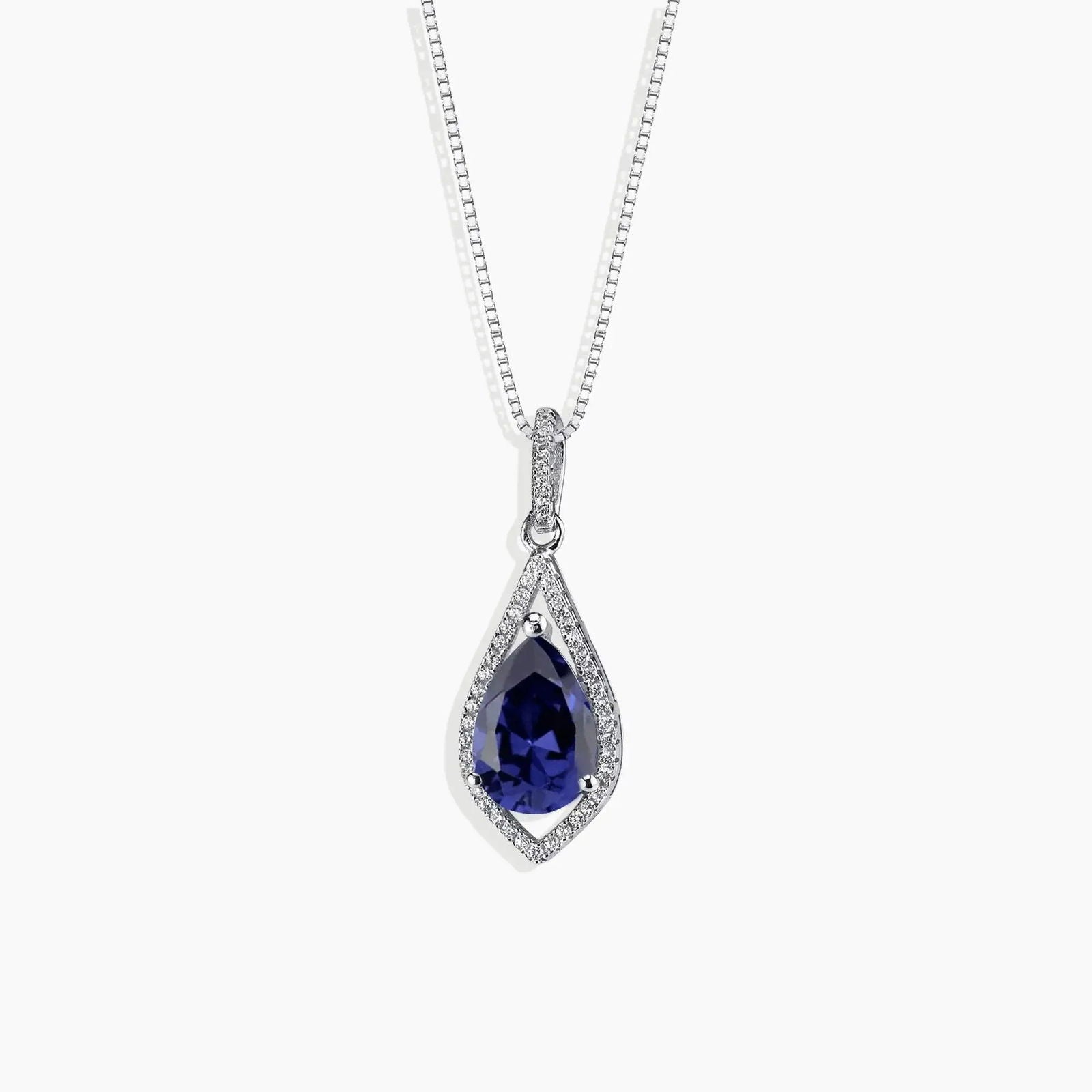 Pear-shaped sapphire necklace in sterling silver with a deep blue gemstone, featuring a sparkling halo design. Elegant and timeless jewellery piece.