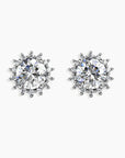 A pair of Sunburst Moissanite Round Stud Earrings on a gray background, featuring a radiant sunburst design