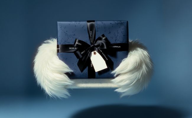 Gift box with a black ribbon and tag on a blue background