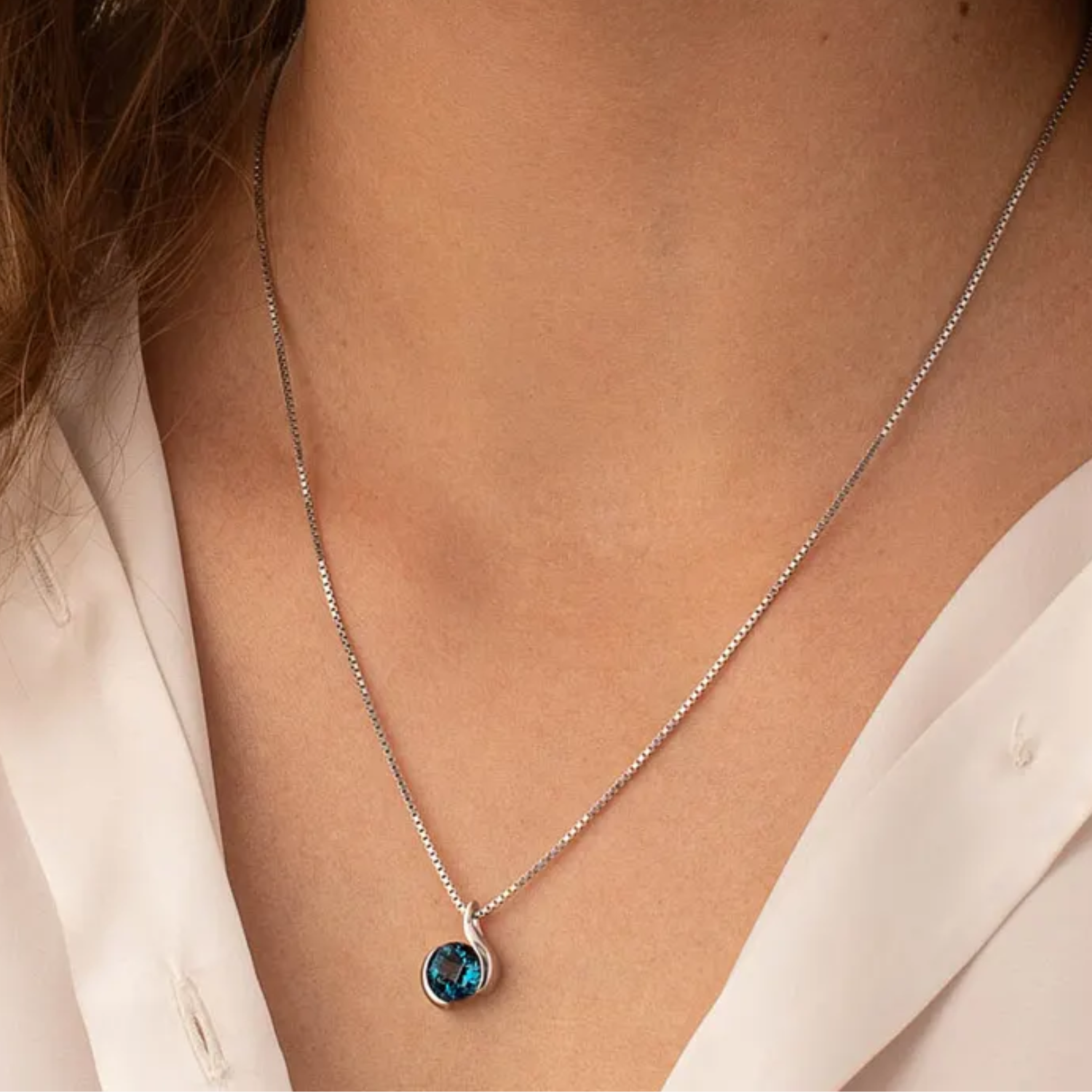 round london blue topaz semi bezel set pendant in silver on a model