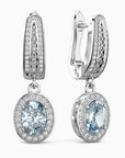 Pair of silver earrings with aquamarine gemstones on a white background
