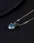 aquamarine round shape pendant necklace on dark background