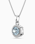 Silver pendant with a blue aquamarine gemstone and clear stones on a white background