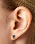 model featuring round black opal stud earrings