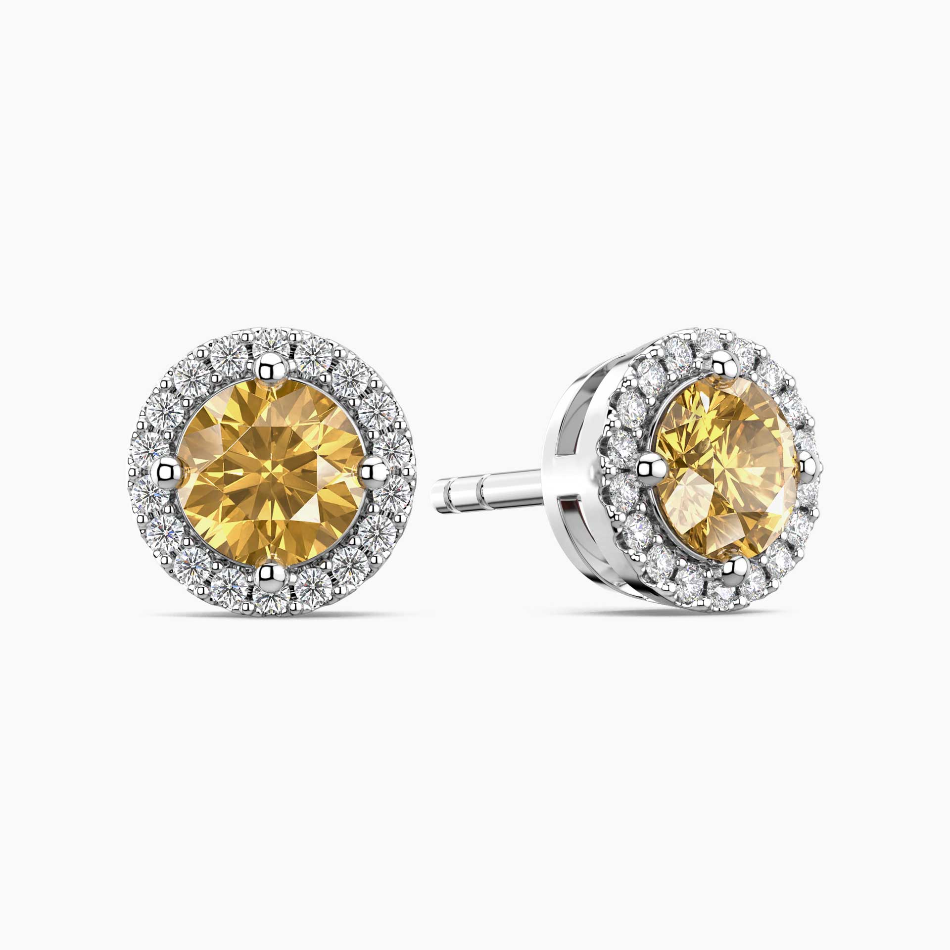 Pair of yellow citrine gemstone earrings with silver halos on a white background
