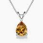 A pear-shaped golden citrine pendant in a three-prong sterling silver setting with a V-shaped bail, hanging from a delicate silver box chain on a white background; the gemstone displays warm amber and honey tones.
