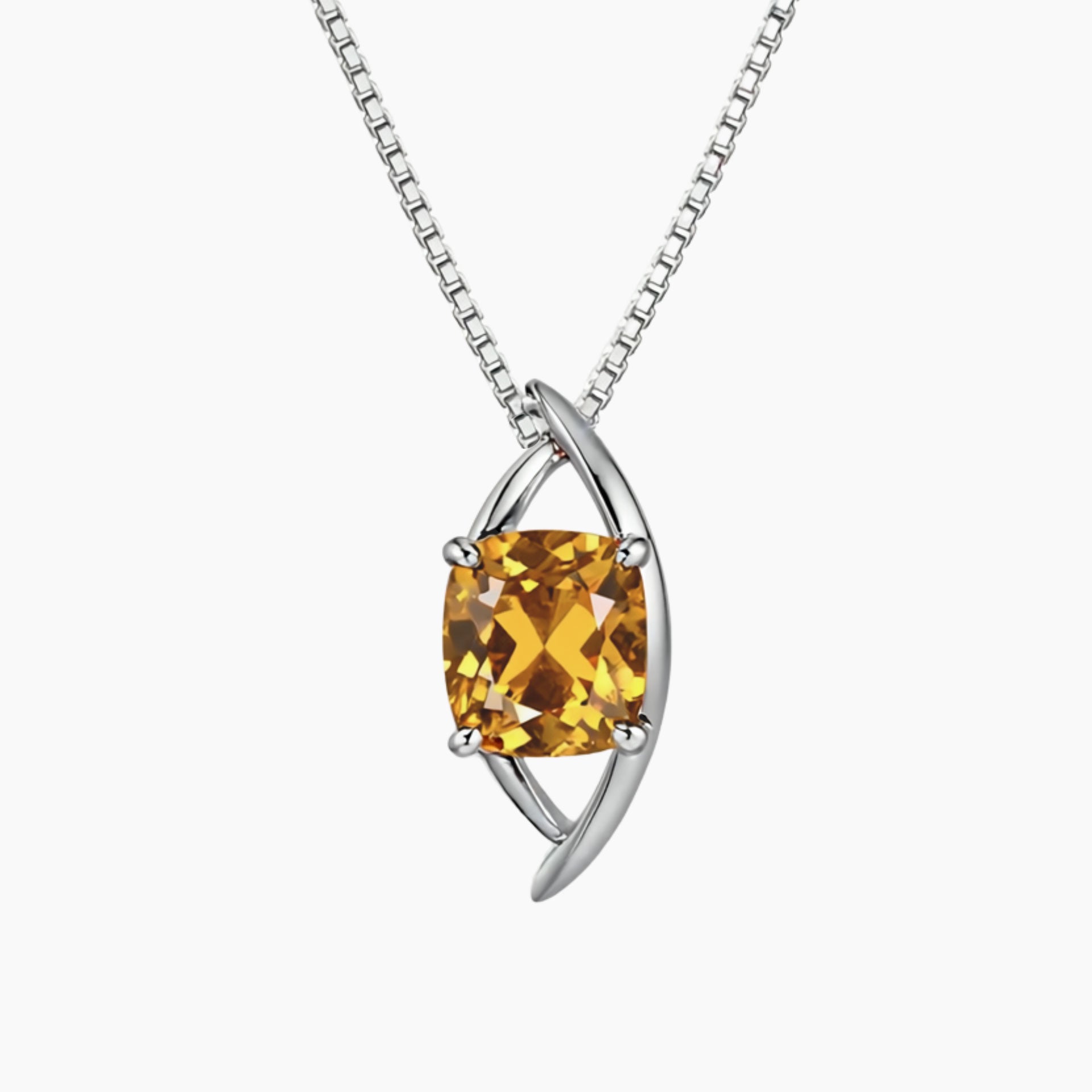 Silver pendant with a yellow gemstone on a white background