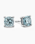 Cushion-cut aquamarine stud earrings in sterling silver, featuring soft blue gemstones set in elegant four-prong mountings.






