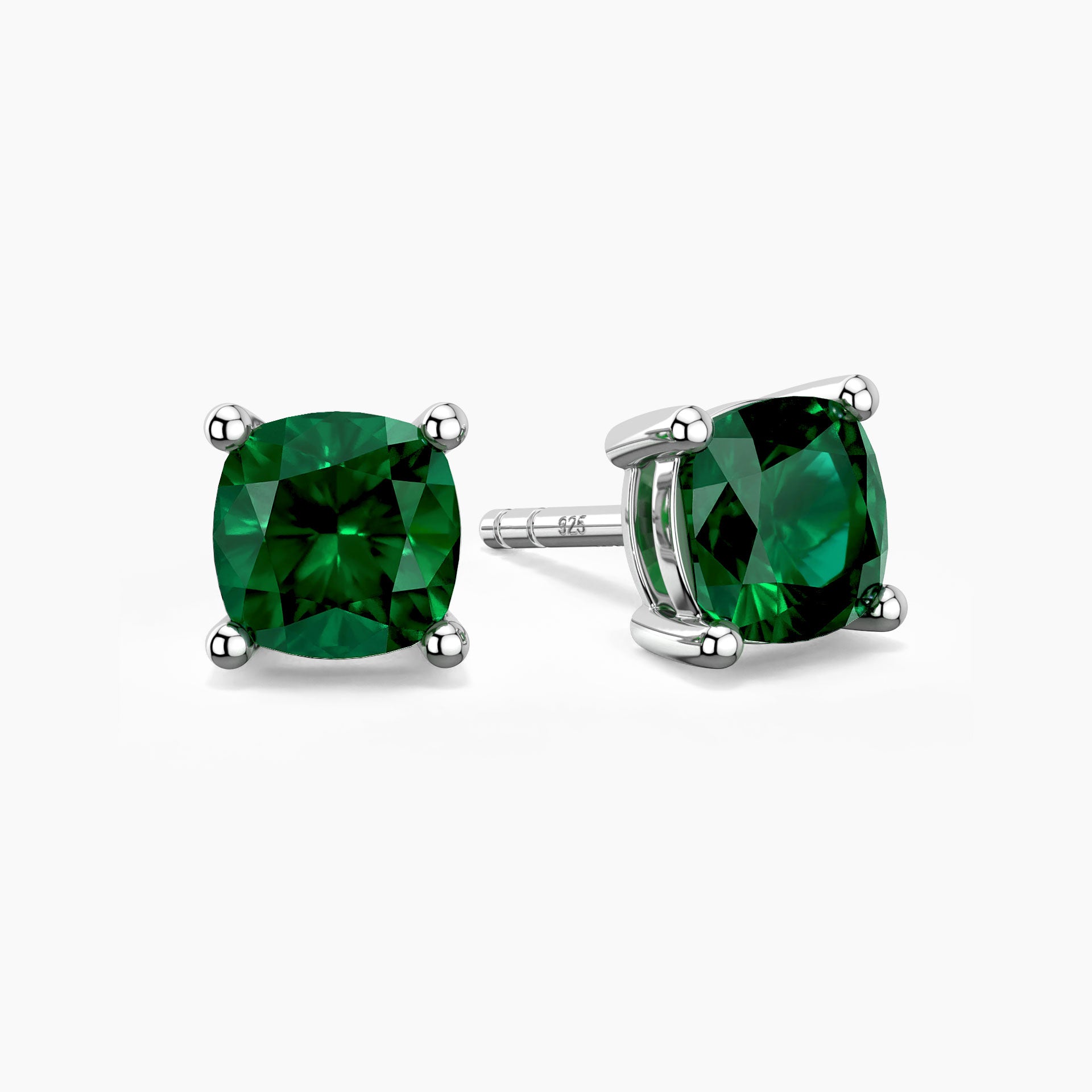 Cushion-cut emerald stud earrings in sterling silver, showcasing vibrant green gemstones held by a classic four-prong setting.