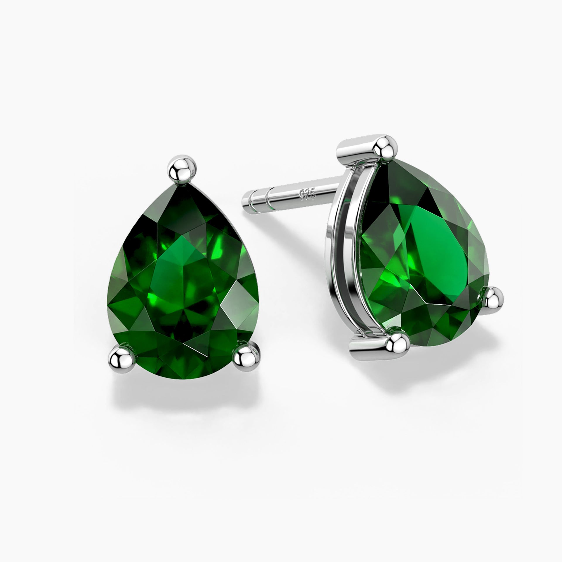 Teardrop-shaped emerald green stud earrings in silver claw setting
