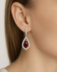 Teardrop-shaped earring with a red garnet gemstone worn by a model.