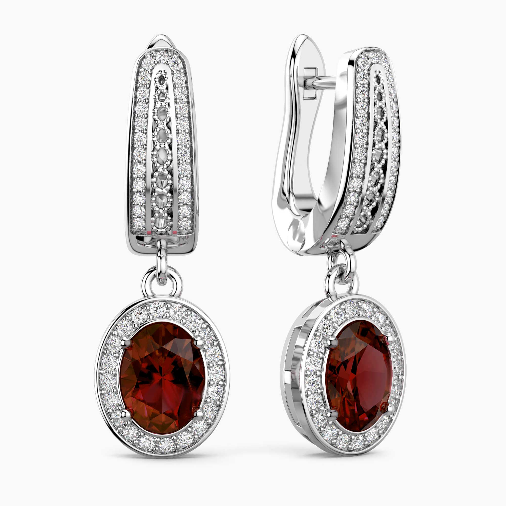 Pair of earrings with red garnet gemstones and diamond accents on a white background