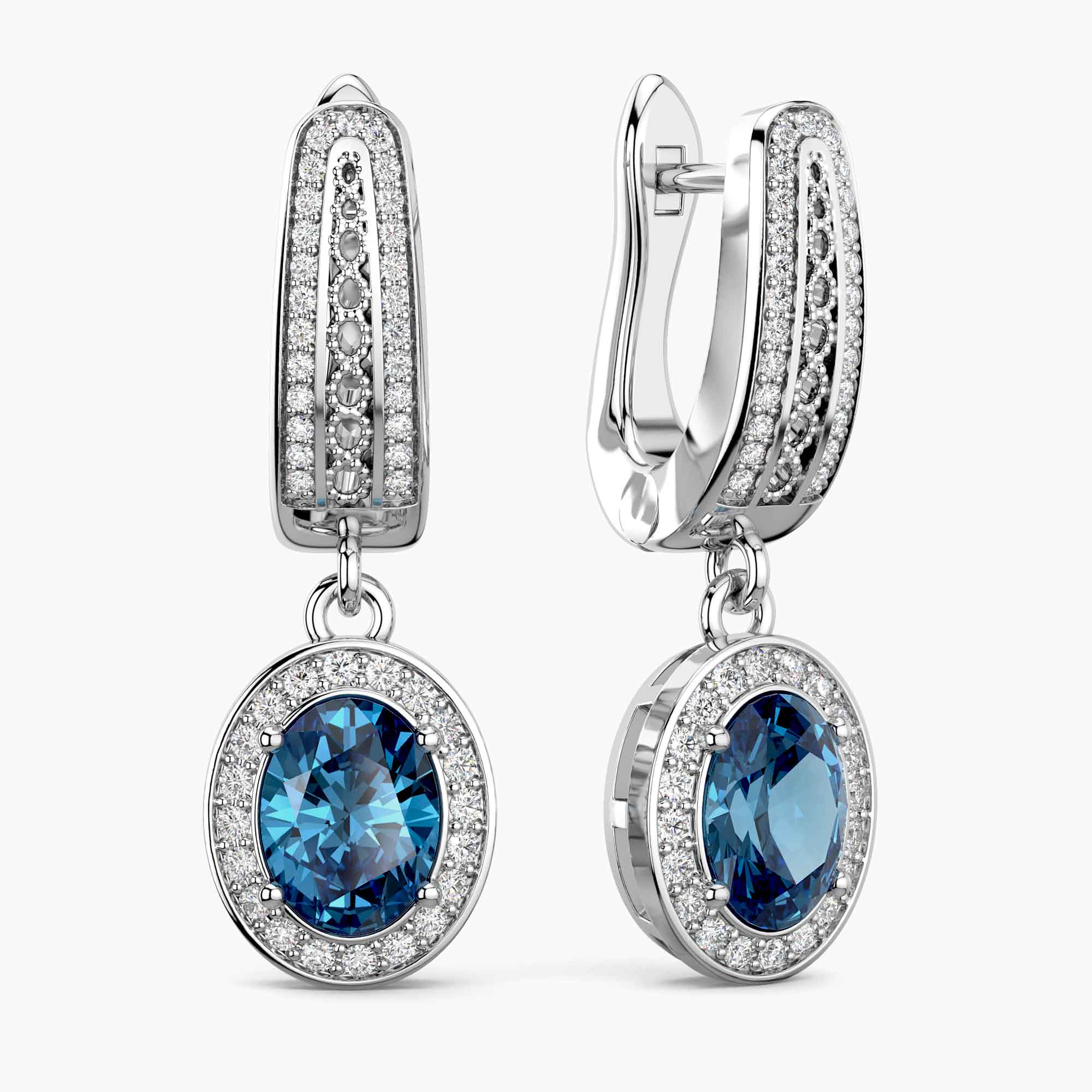Pair of earrings with london blue topaz gemstones and silver accents on a white background