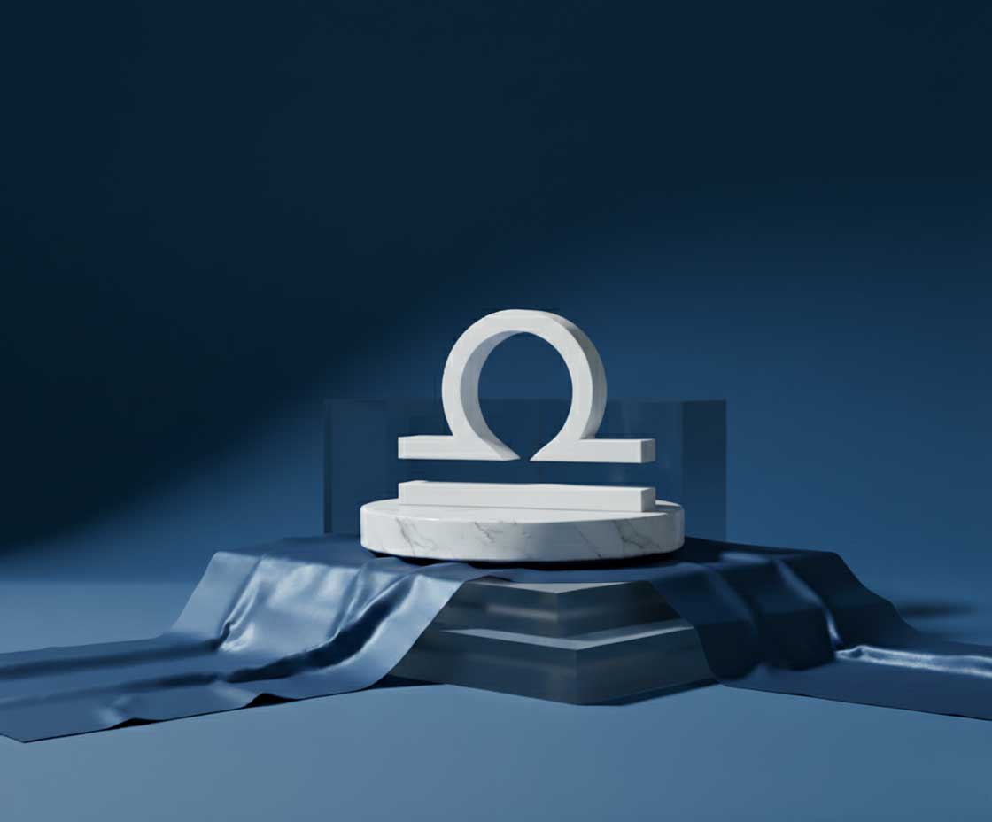 Geometric marble sculpture of libra sign on a blue platform with a dark blue background