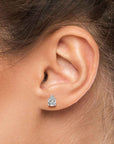 Model wearing teardrop-shaped moissanite stud earring in silver claw setting
