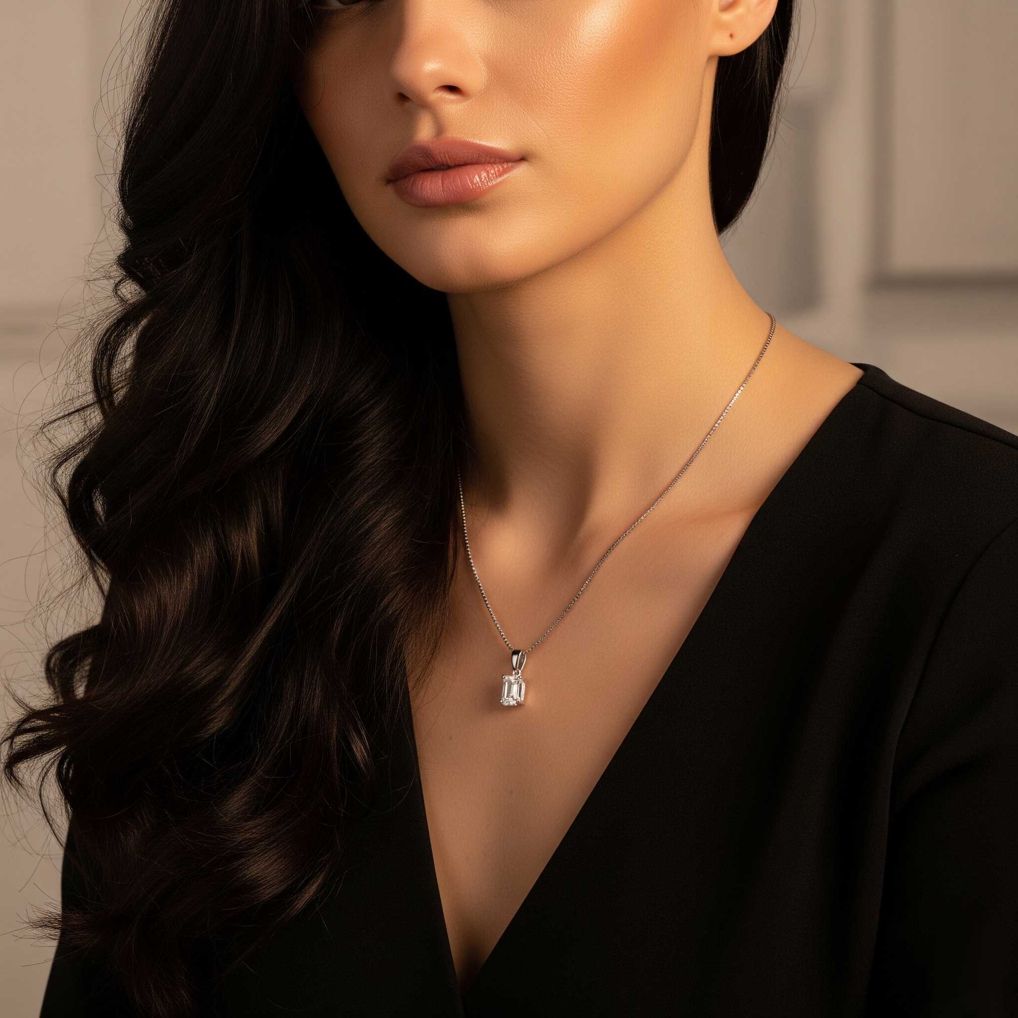 Woman wearing a black top with a silver emrald cut moissanite pendant.