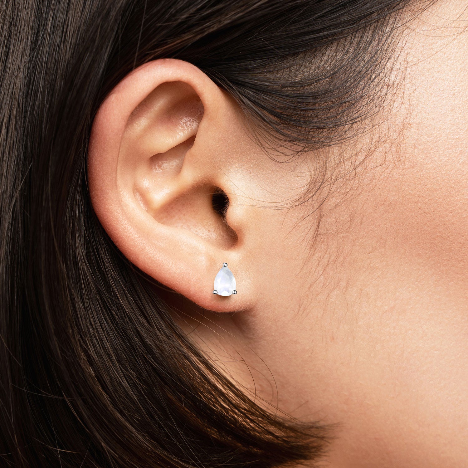 Delicate pear-cut moonstone stud worn on ear – minimalist moonstone earring in silver for everyday wear