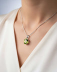 Necklace with a green peridot pendant on a mannequin wearing a white top