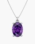 Oval-cut purple amethyst pendant in a four-prong silver setting, suspended from a delicate silver chain, displayed on a white background