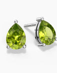 Two pear-shaped bright green peridot gemstones set as sterling silver stud earrings, one shown head-on and the other at a slight angle, each secured by three polished prongs on a white background.