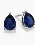 ChatGPT said:
Alt: Two pear-shaped deep-blue sapphire gemstones set as sterling silver stud earrings, one shown head-on and the other at a slight angle, each held by three polished prongs on a white background.