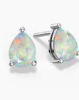 Two pear-shaped white opal stud earrings in three-prong sterling silver settings—one shown head-on and the other at a slight angle revealing the “925” stamp on the post—displaying soft pastel flashes of green, pink, and blue play-of-color on a white background.
