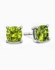 Pair of sterling silver stud earrings featuring cushion-cut green peridot gemstones with four-prong settings.