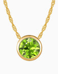 Bezel set round peridot necklace in 18K gold with a sparkling natural gemstone, perfect for August birthstone gifts.