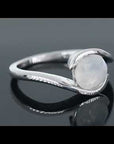 Video preview of the moonstone semi bezel ring rotating to display its shimmer and unique open band design