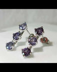 Video preview of Alexandrite three-stone earrings showcasing colour shift and sparkle under light