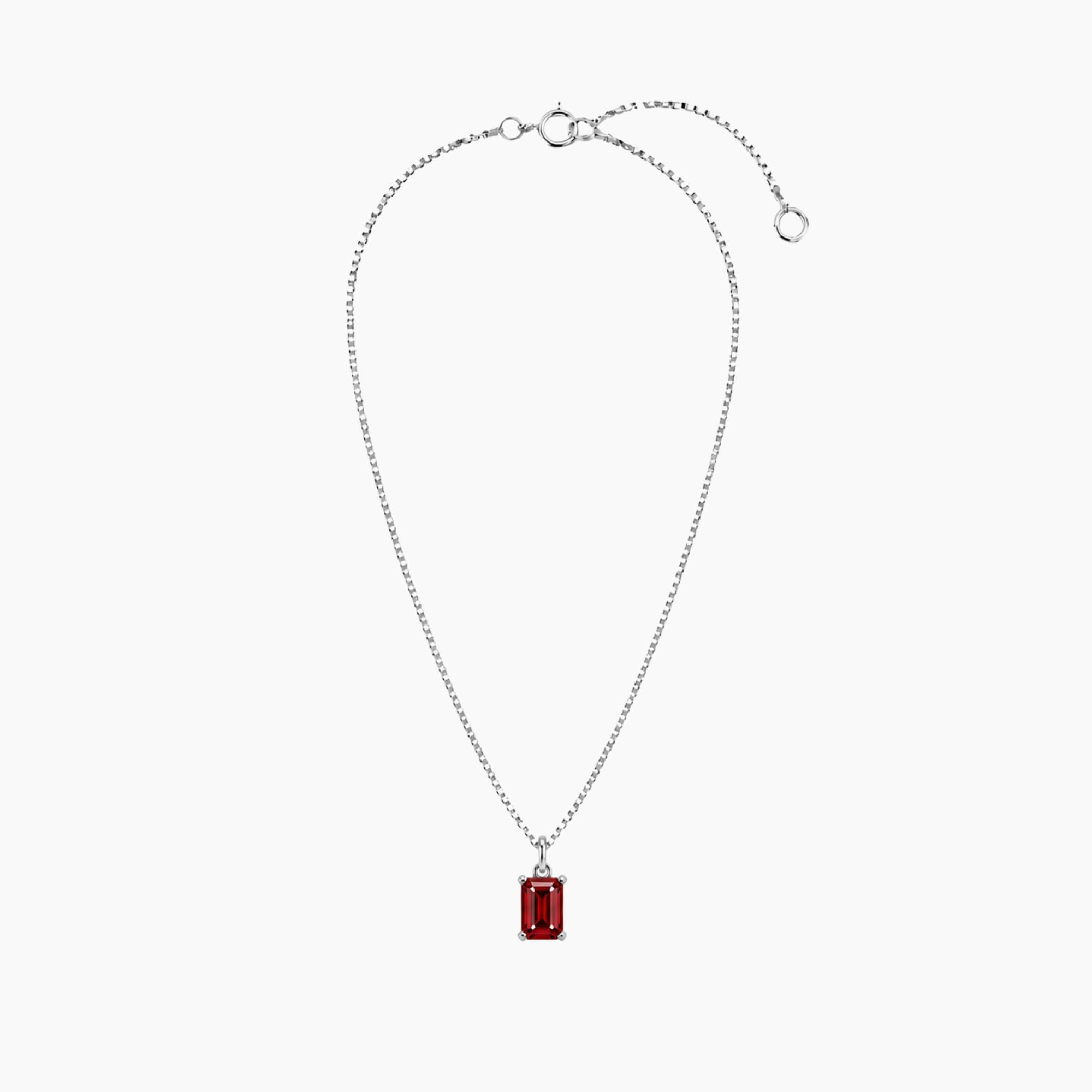Silver ruby emerald cut necklace with a red gemstone pendant on a white background