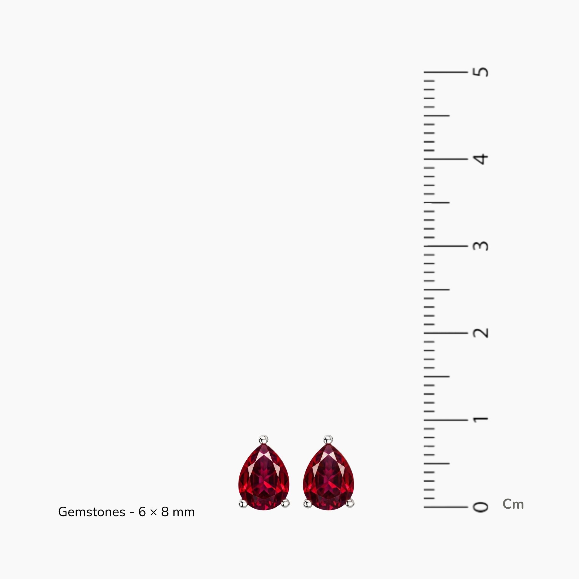 A pair of teardrop-shaped red ruby gemstone stud earrings on a light gray background, with a vertical centimeter ruler on the right and text reading 'Gemstones - 6 x 8 mm' on the left.