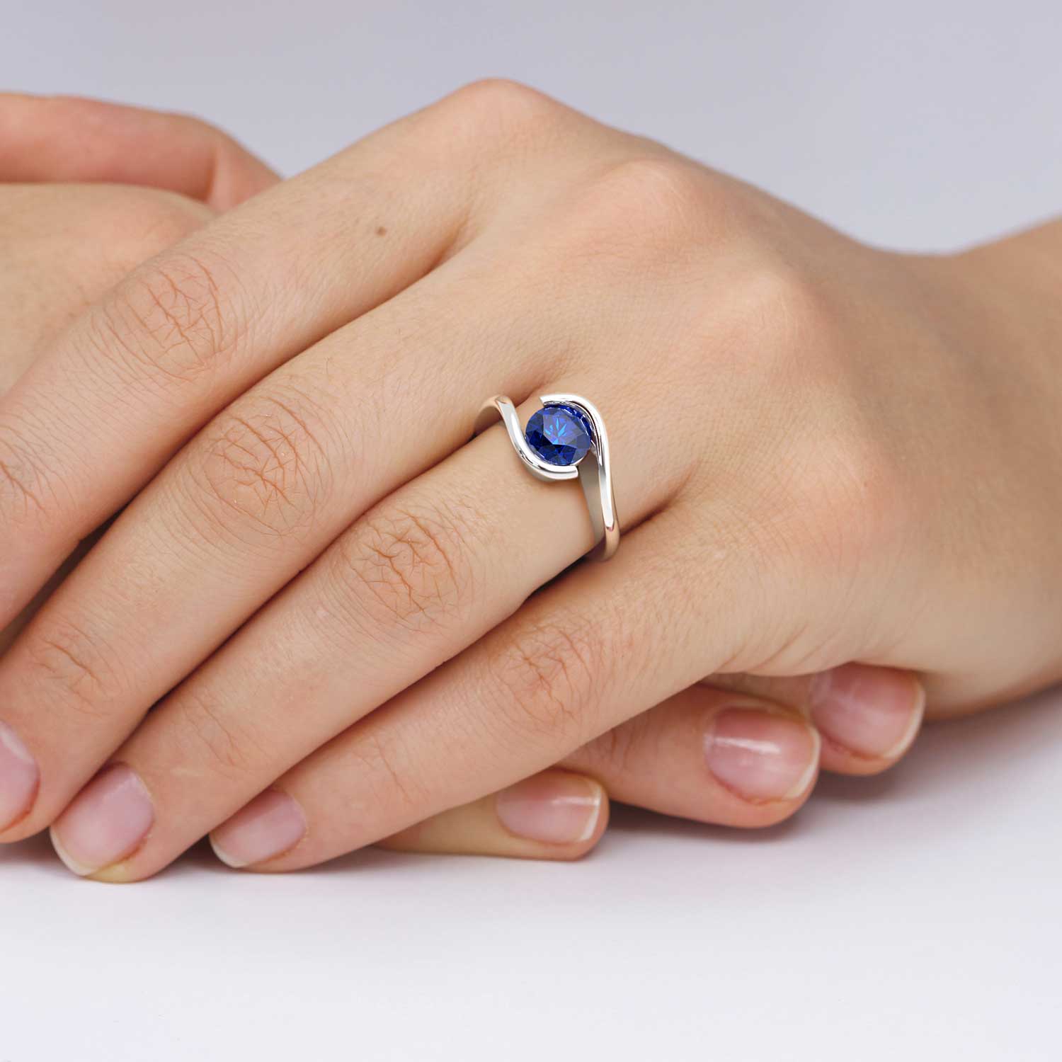 hand with semi bezel set sapphire ring