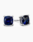 Cushion-cut sapphire stud earrings in sterling silver, showcasing vivid blue stones in elegant four-prong mounts.