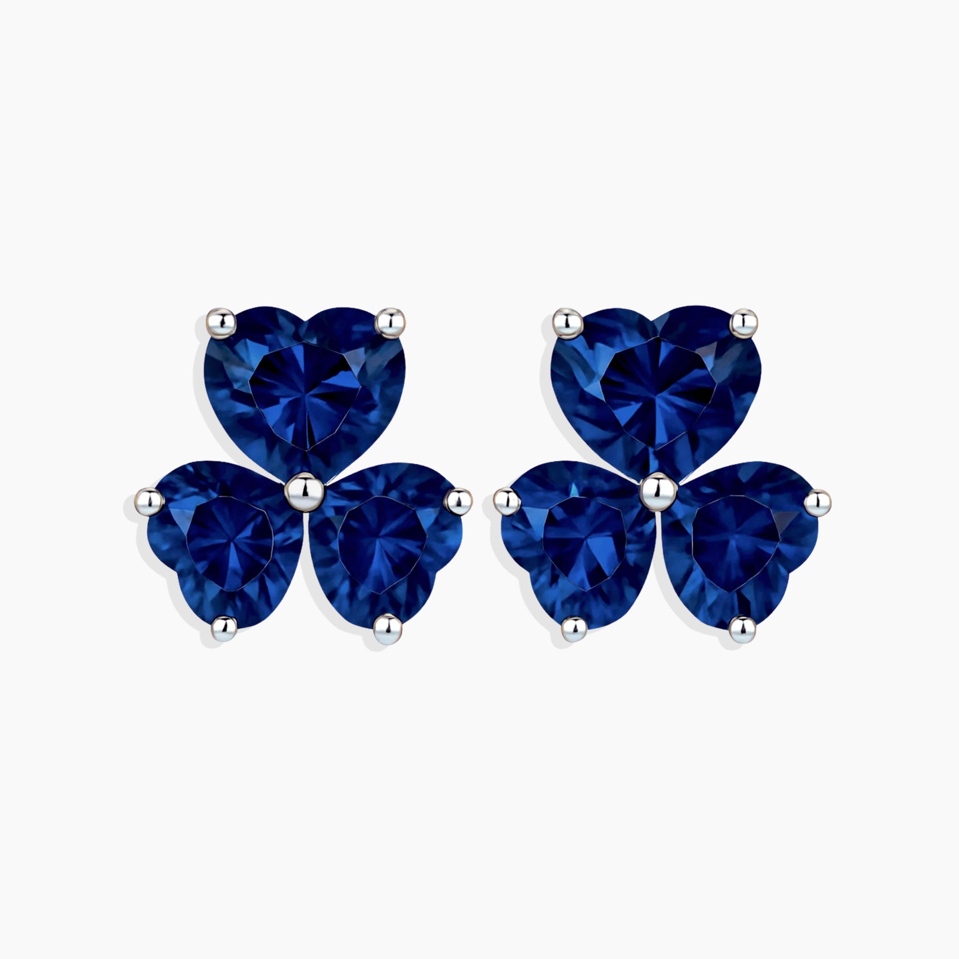Pair of blue heart-shaped stud earrings on a white background