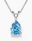 A  pear-shaped Swiss blue topaz pendant in a three-prong sterling silver setting with a V-shaped bail, hanging from a delicate silver box chain on a white background; the gemstone features vibrant sky-blue hues with brilliant faceting.
