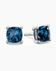 Cushion-cut blue topaz stud earrings in sterling silver, showcasing bright blue gemstones secured in elegant four-prong settings.