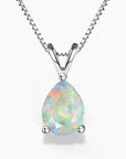 A pear-shaped white opal pendant in a three-prong sterling silver setting with a V-shaped bail, suspended from a delicate silver box chain on a white background; the opal displays a soft play-of-color with pastel flashes of green, pink, and blue.
