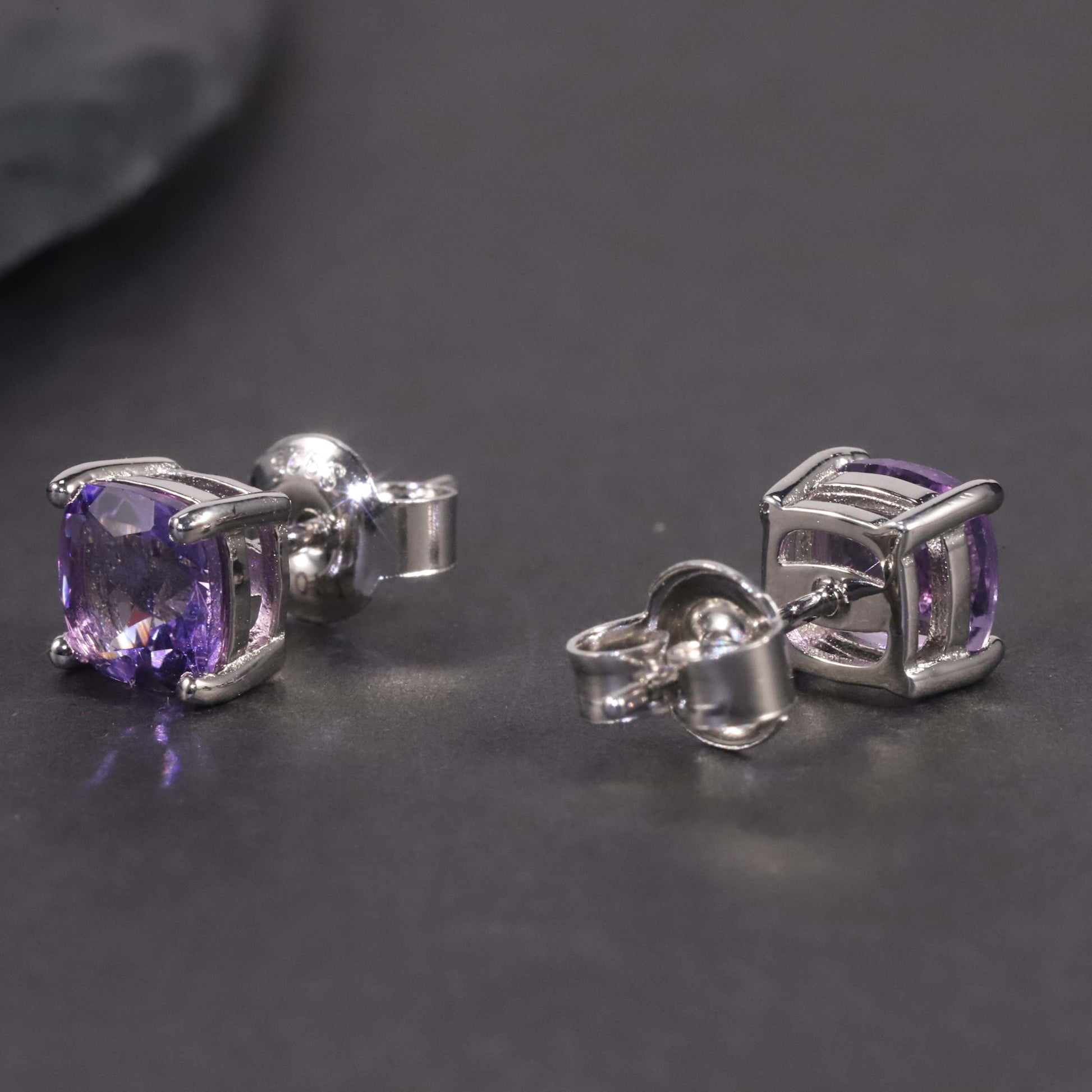 another angle of cushion cut amethyst studs in dark background