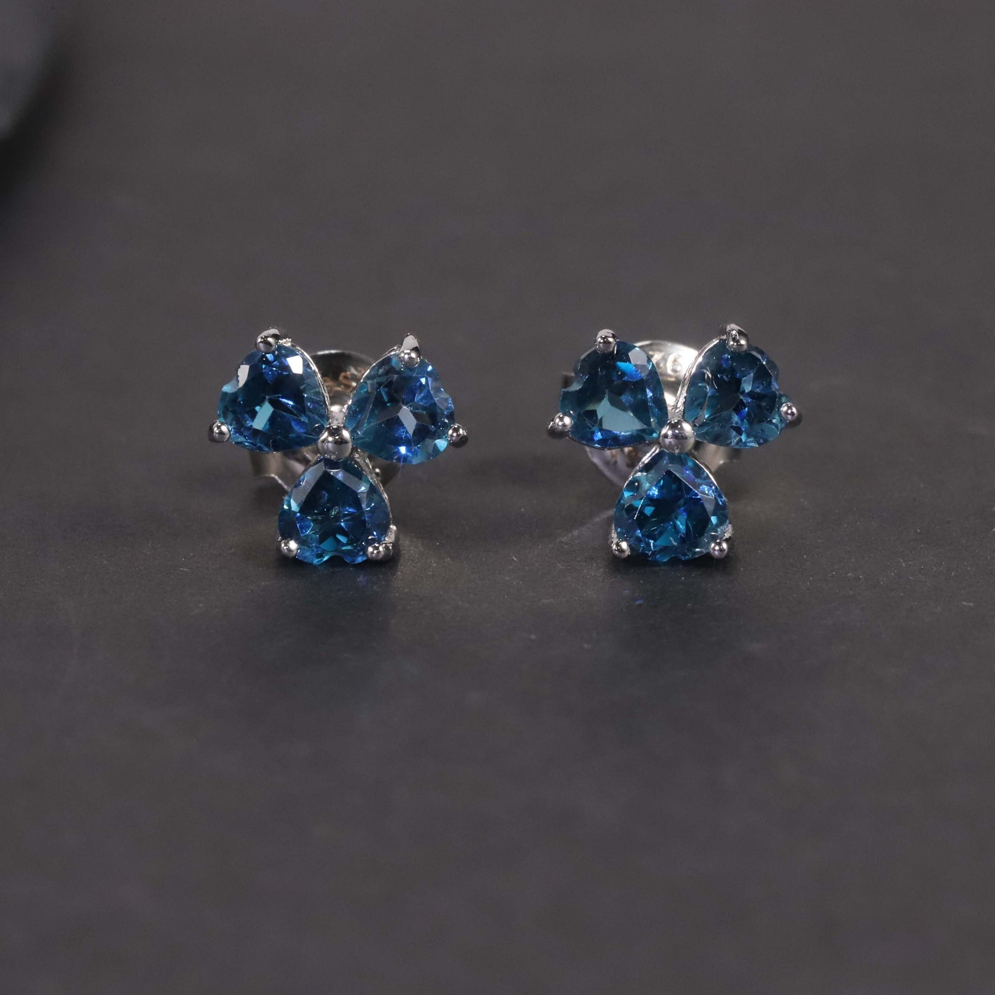  view on dark background of flower-shaped silver London blue topaz jewellery